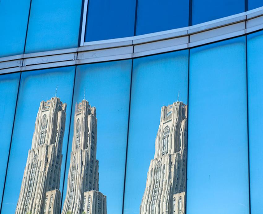A reflection of the Cathedral of Learning in the window of Mervis Hall, an academic building at the University of Pittsburgh.
