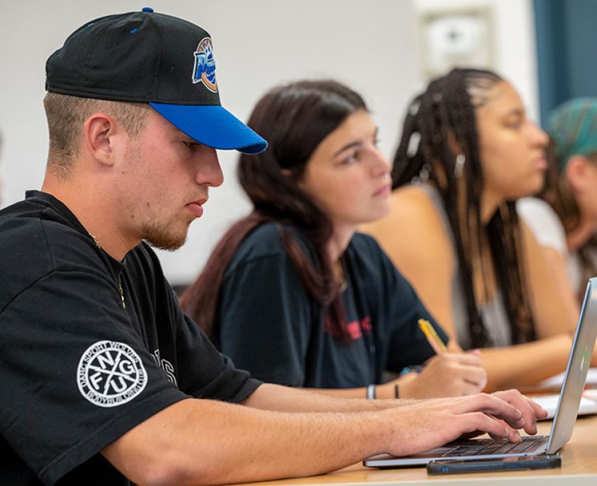 A row of students taking notes in class