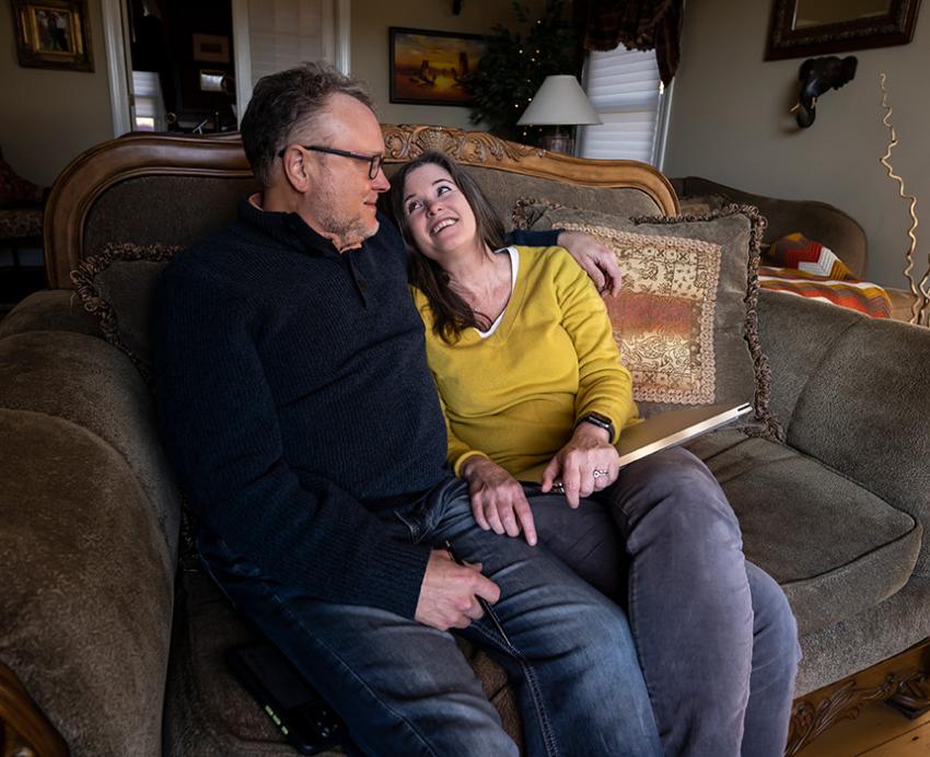 The Vorps sit on a couch in their home