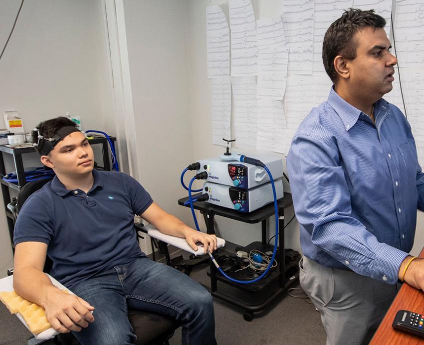 A subject and professor look at brain scans on a monitor