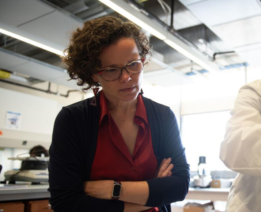 Carla Ng watches a student pipette in the lab