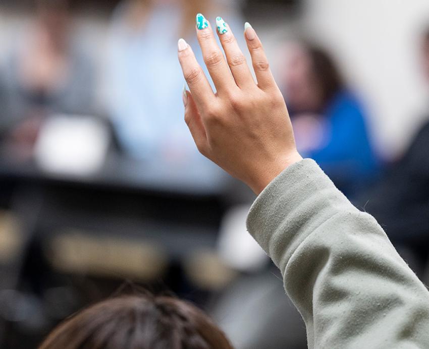 A raised hand in a classroom