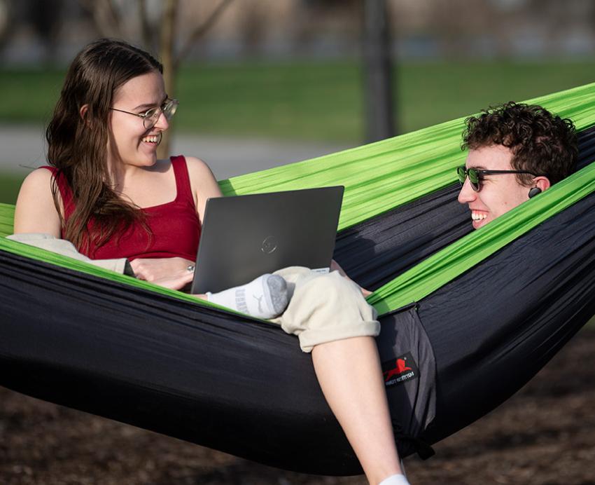 Two students sit in a hammock