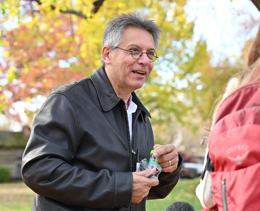 Hatfull holds sample bottles while speaking to a camera crew