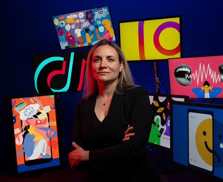 Choukas-Bradley in front of screens with social media logos