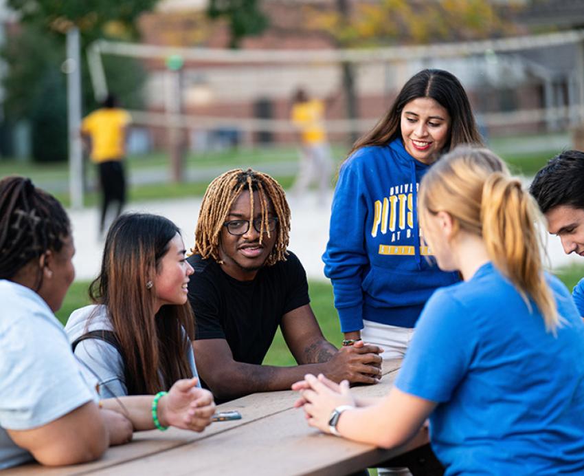 Pitt-Bradford students talk around an outdoor table