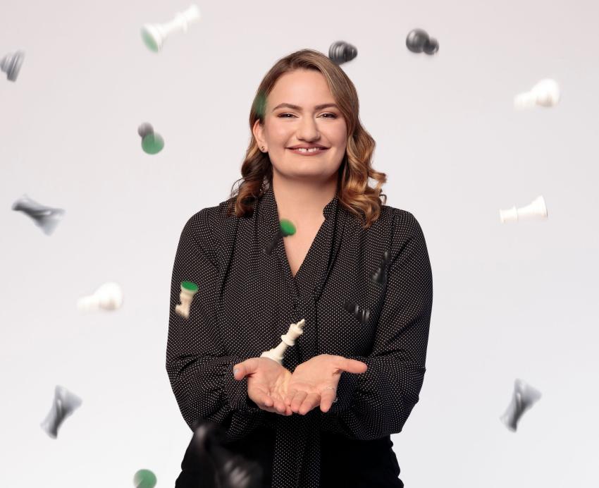 Woman tosses chess pieces into the air.
