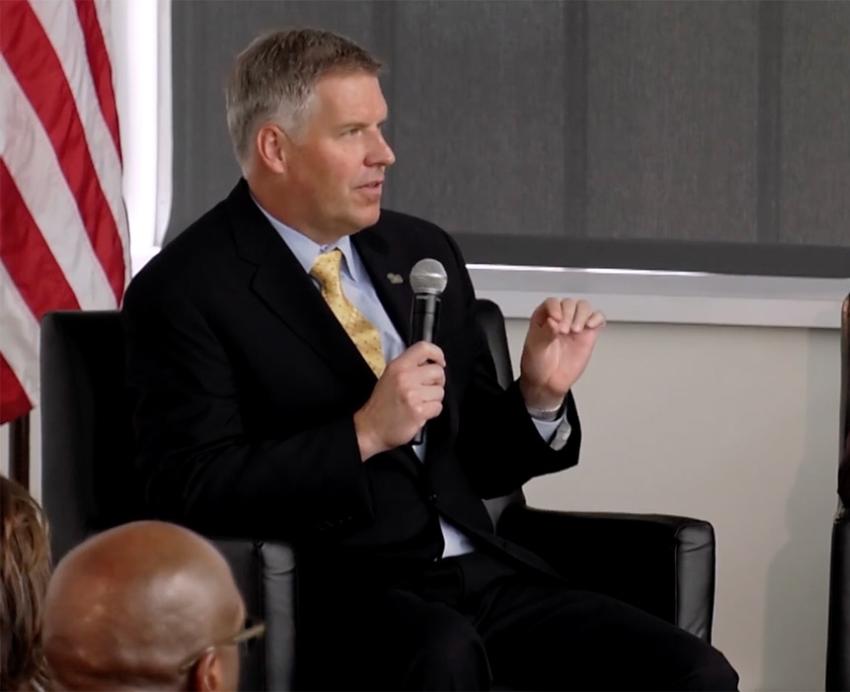 Chancellor Gallagher talks into a microphone during a panel