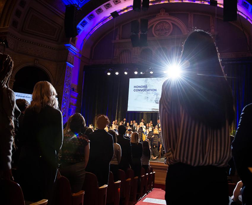 People stand in pews at Honors Convocation