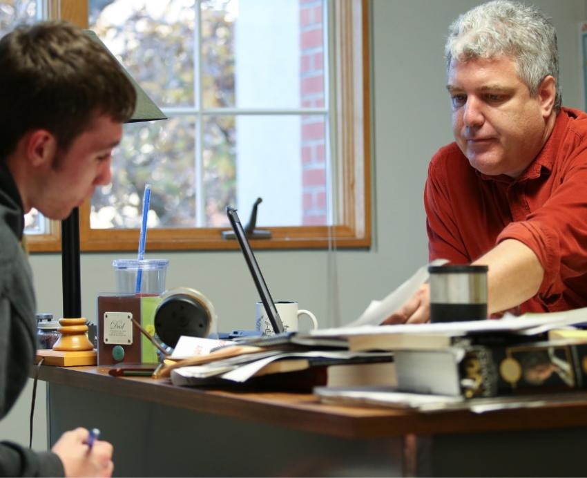 A professor helps a student during office hours.