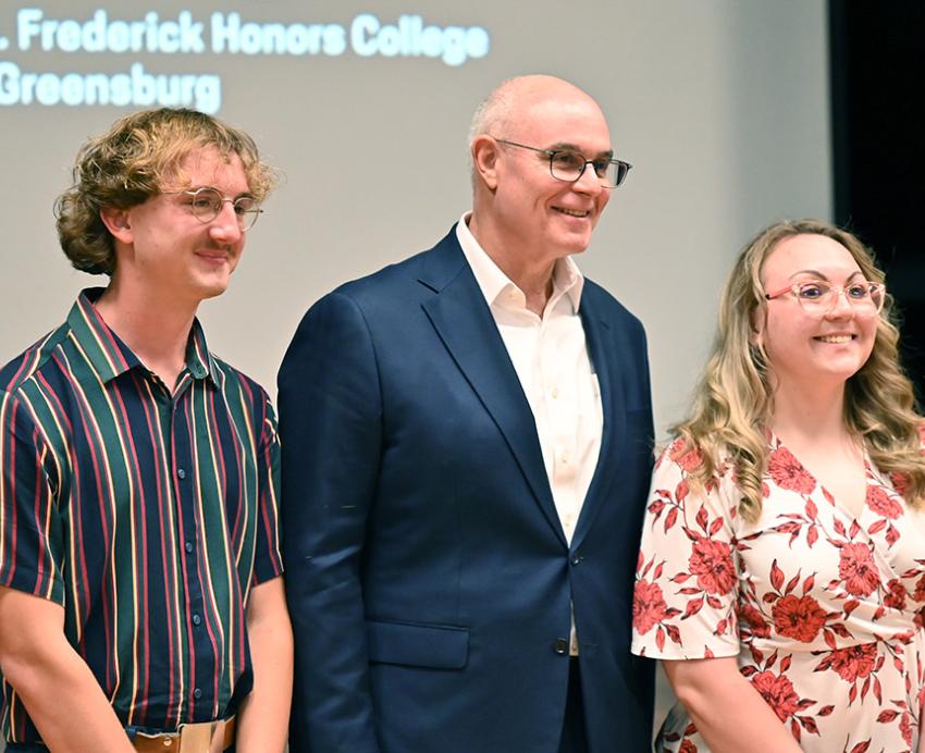 David Frederick stands with three honors students