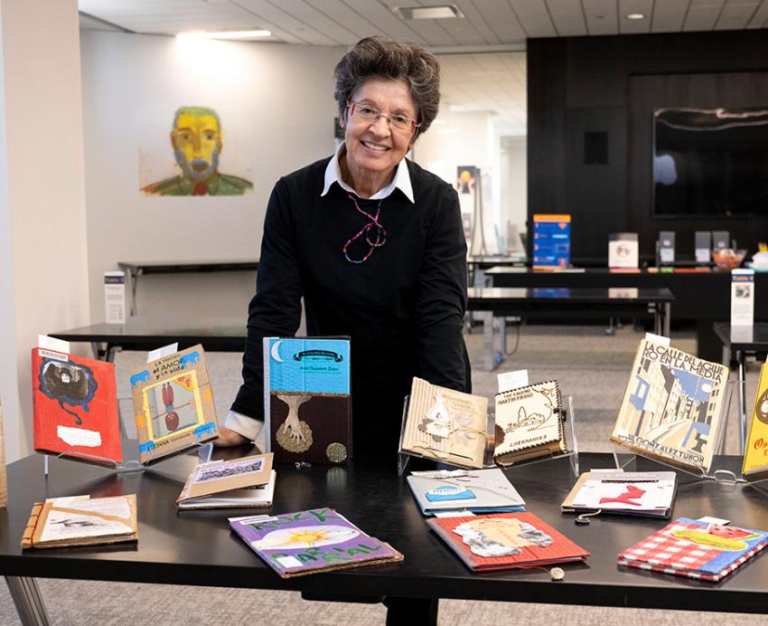Mantilla stands behind a table of books