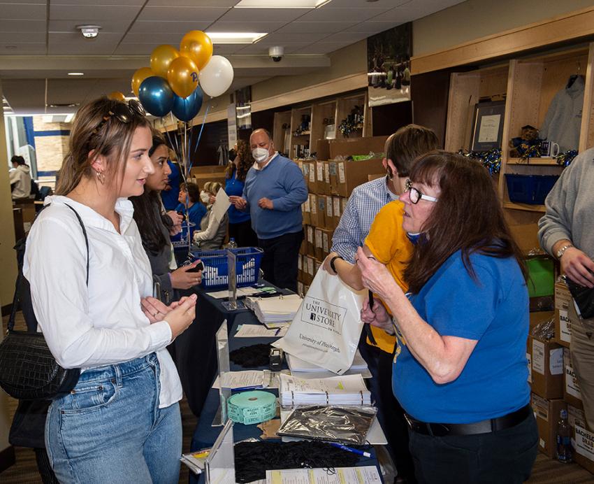A student picks up grad gear during Graduation Central in the University Store on Fifth.