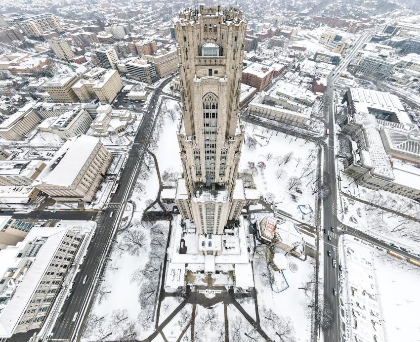 An aerial view of the Cathedral of Learning during the winter that shows its entire front facade.