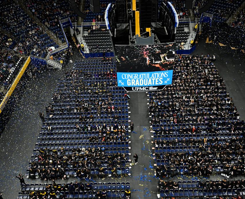 Confetti falls over winter commencement graduates and attendees.