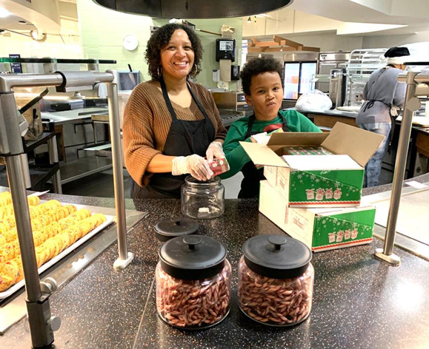 An adult and child volunteer help prepare meals for Christmas Day at Pitt.
