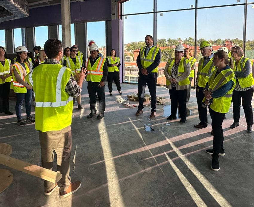 People in yellow vests tour a construction site