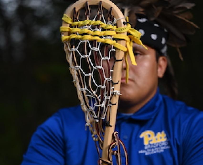 Man holding wooden lacrosse stick