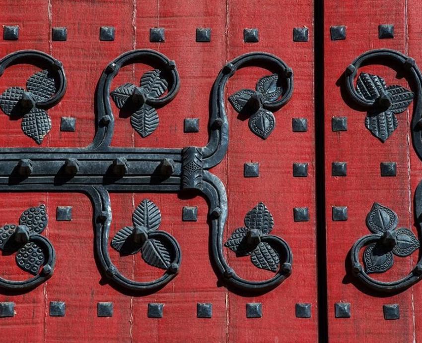 Closeup of red door with black ironwork