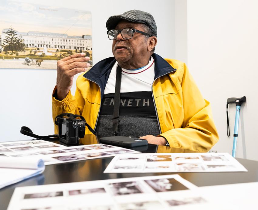 Hightower sits at a table, with pages of his photographs before him.