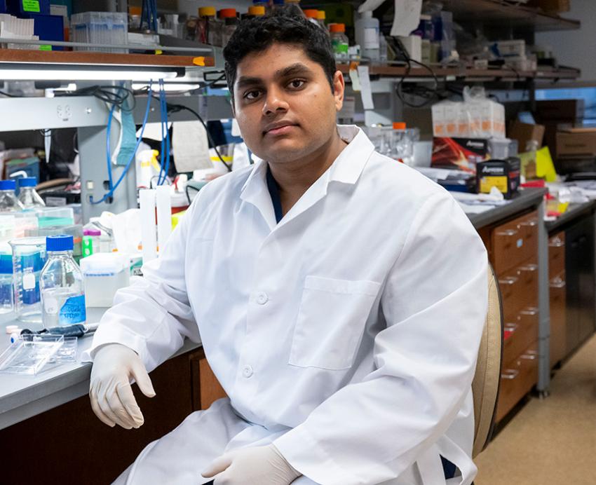 Rohit Mantena sits at a lab bench