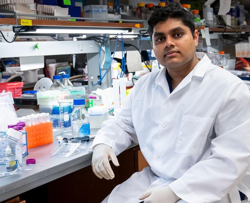 Rohit Mantena sits at a lab bench