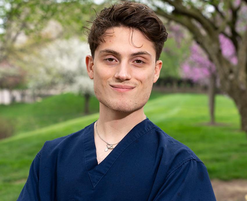 Joao Barichello posing in scrubs on Pitt's campus