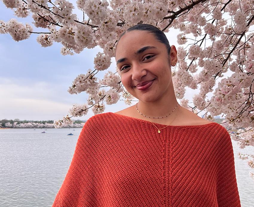 Mackenzie Evans in front of a blossoming tree