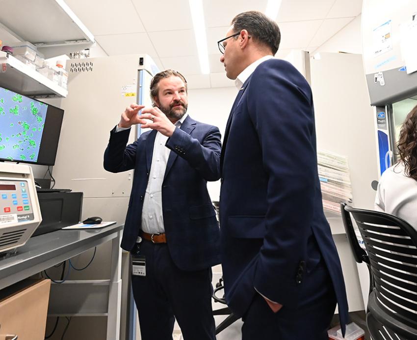 Gov. Shapiro talks to a researcher in a lab.
