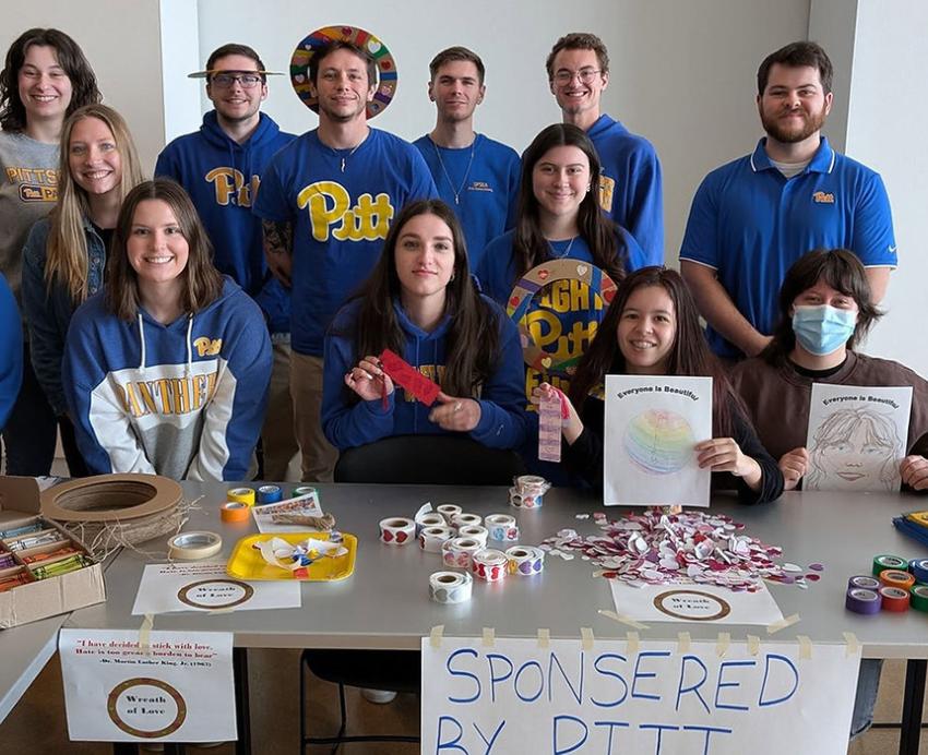 Students pose behind a table