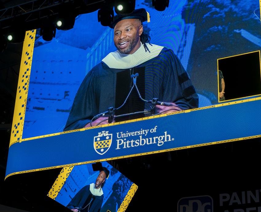 Fitzgerald speaks on stage, visible through arena video board
