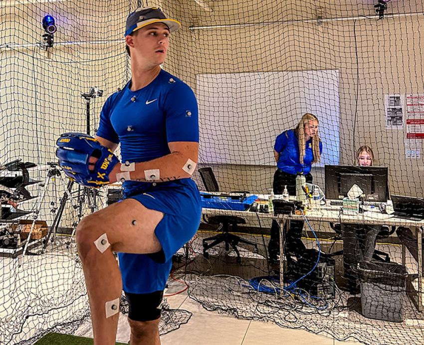 Drew Lafferty dressed in pitching gear and sensors about to throw a baseball