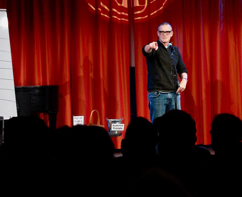 Man on stage pointing at crowd