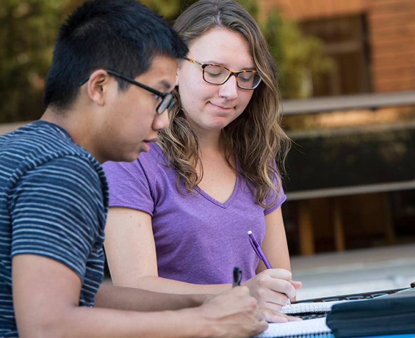Students take notes in a notebook
