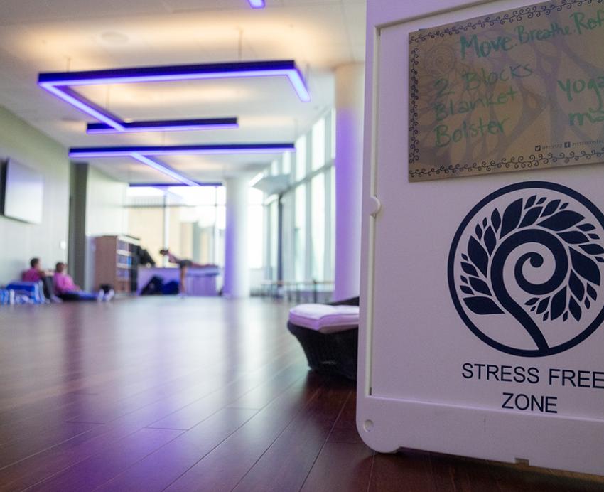 People stretch behind a sign at the entrance of the Stress Free Zone.