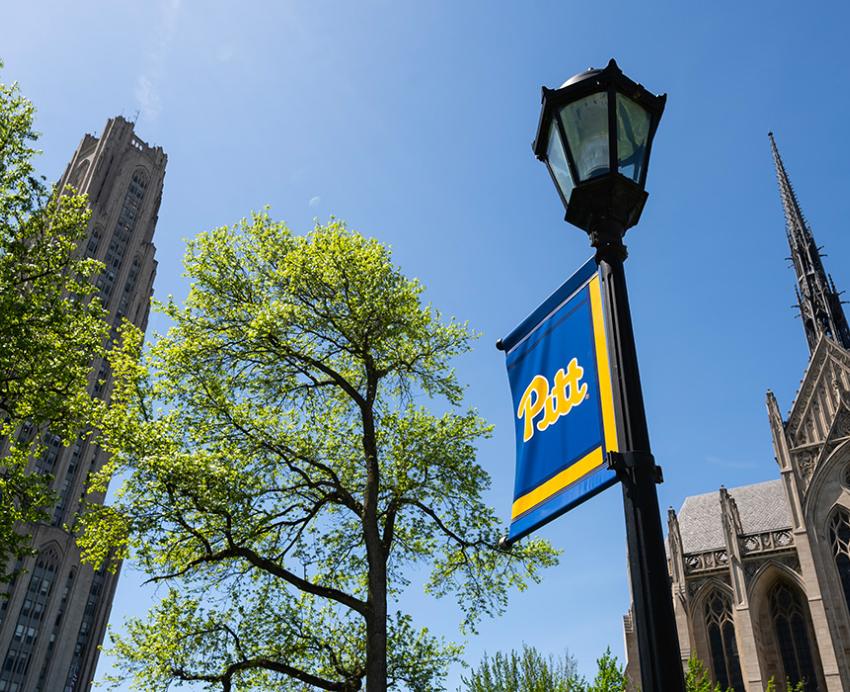Cathedral of Learning and Heinz Chapel with a lamppost decorated with a Pitt banner