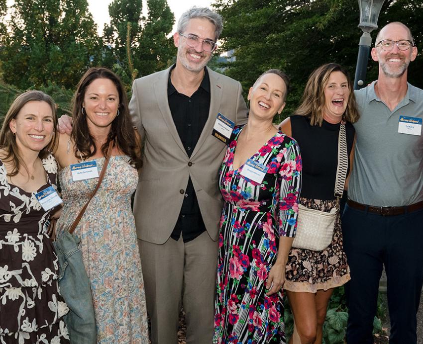 Alumni standing together and happily posing for a photo