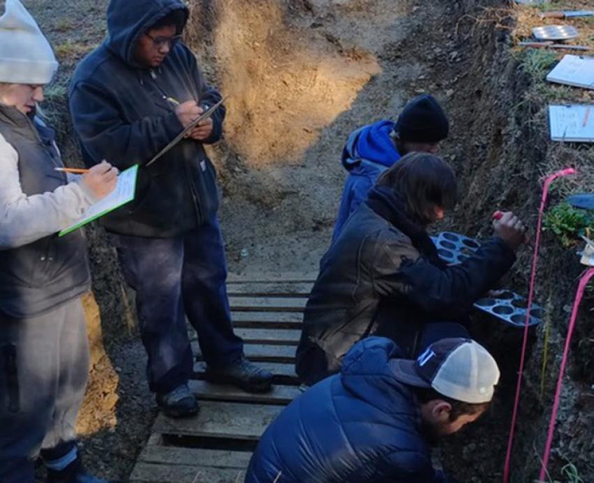 Soil judges watch participants gather samples