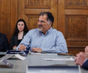Afshin Beheshti sitting at a table with his name displayed