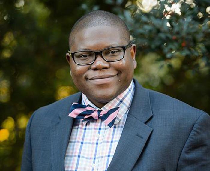 Darris Means wearing suit, smiling