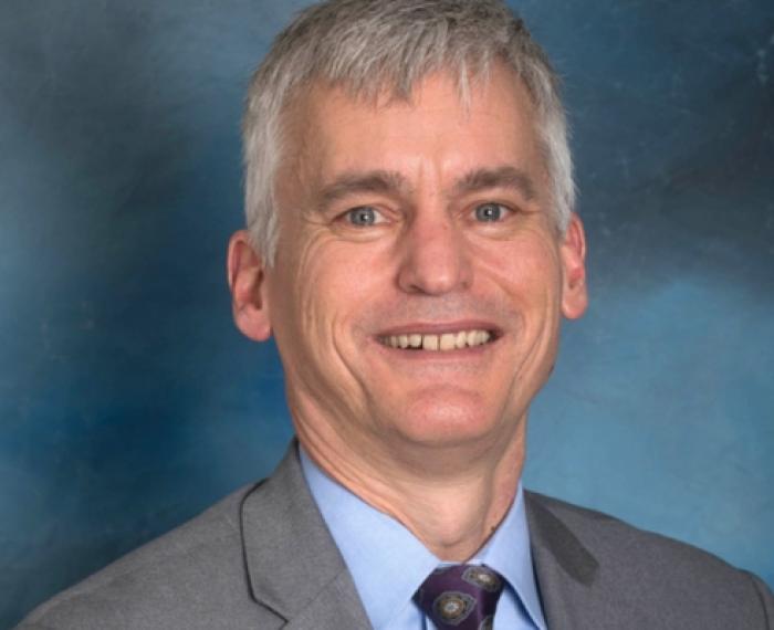 Scott Bernotas portait, smiling with grey suit
