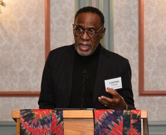Porter in black standing at a podium