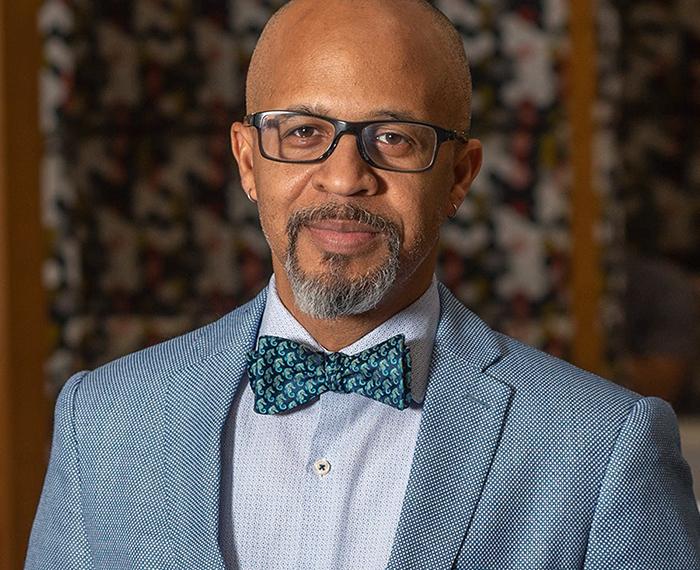 Gabby Yearwood wearing grey suit with blue bowtie