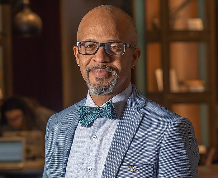 Gabby Yearwood wearing grey suit with patterned blue bowtie