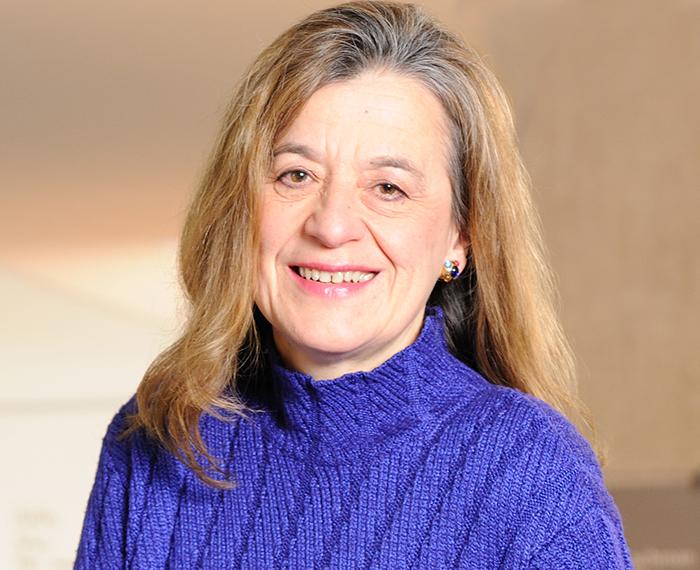 Anna Balazs wearing a purple sweater and smiling