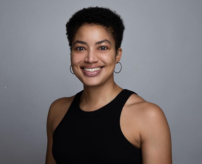Alaina Roberts smiling in black shirt in front of grey background