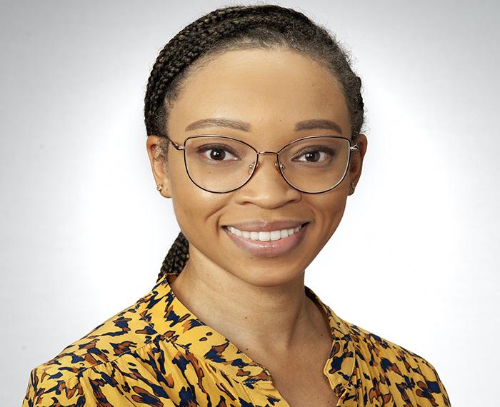 Amber Johnson wearing yellow and black patterned shirt in front of white background