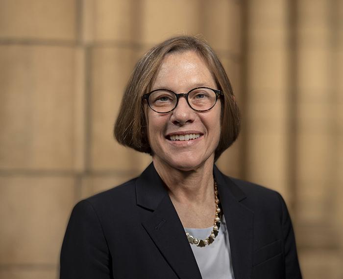 Ann Cudd wearing a black jacket and smiling for portrait photo