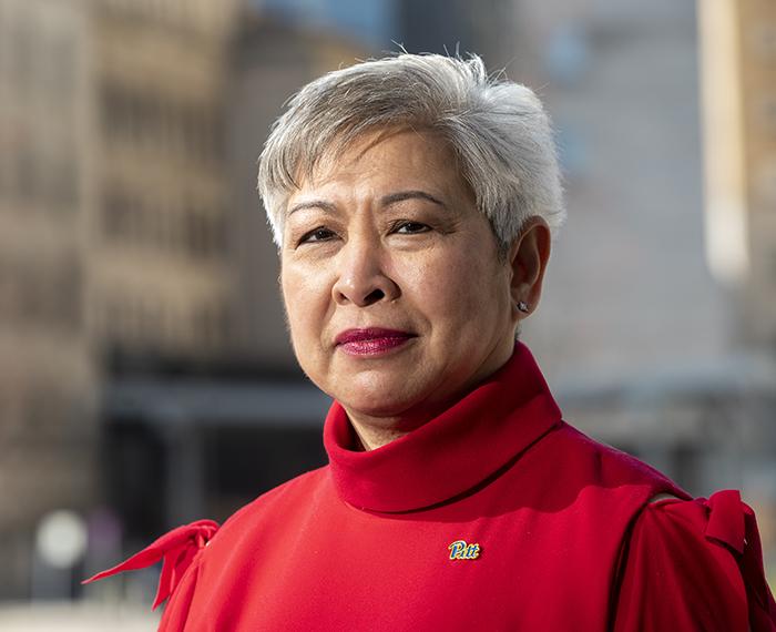 Maureen Lichtveld wearing red sweater with blue and gold Pitt pin
