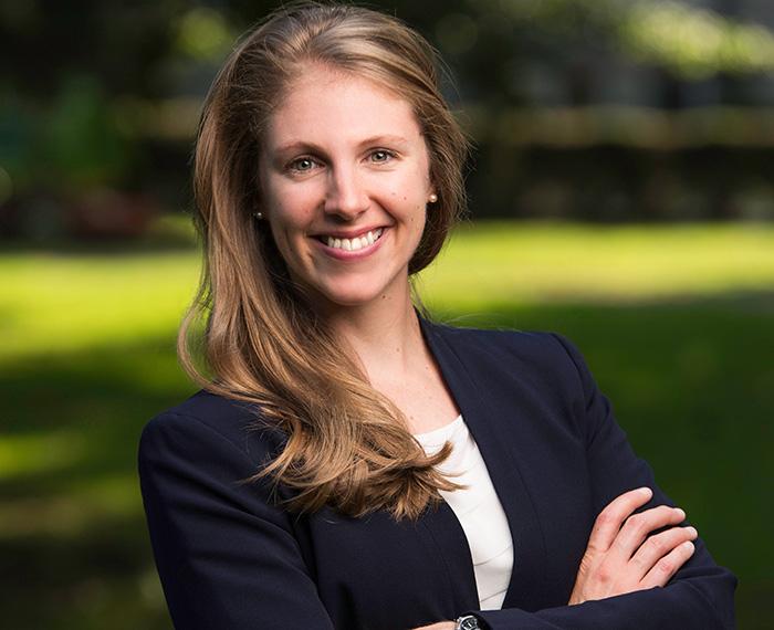 Rebecca Reed smiling outside with black jacket and white shirt